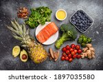 Small photo of Anti inflammatory diet concept. Set of foods that help to reduce inflammation - plant based ingredients, fresh fruit, green vegetables. Healthy diet products, top view, stone background