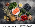 Small photo of Anti inflammatory diet concept. Set of foods that help to reduce inflammation - plant based ingredients, fresh fruit, green vegetables. Healthy diet products, top view, stone background. Toned