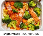 Small photo of Top view close up of healthy baked fish salmon steaks, broccoli, cauliflower, carrot in casserole dish. Cooking a delicious low carb dinner, healthy nutrition concept.