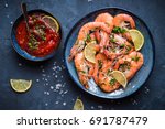 Cooked shrimps on plate with lemon, salt, sauce. Seafood appetizer. Top view. Big red prawns for lunch on rustic stone background. Healthy clean eating/diet. Shrimps close-up. Prepared large prawns