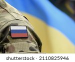 Flag of Russia on military uniform and flag of the Ukraine at background. Russia VS Ukraine.