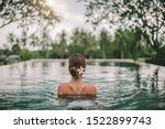 Young girl swimming in infinity pool with in private villa resort. Travelling to Ubud, Bali.