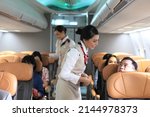 Small photo of air hostess service on plane , flight attendant checking and closing cabin compartment in airplane