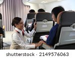 air hostess service on plane , flight attendant checking and closing cabin compartment in airplane