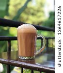 Small photo of Teh Tarik, a Malaysian delicacy is a mixture of tea and condensed milk, a favourite pass time drink in Malaysia. Focus separation to emphasise the mug.