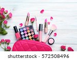 Different makeup cosmetics on white wooden table