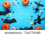 Halloween bats with pumpkins on blue wooden table