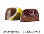 Cut luxury handmade bonbon with chocolate ganache and berry or fruit purees filling isolated on white background. Exclusive handcrafted colorful candies. Product concept for chocolatier