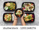 Catering service menu presentation. Woman serving plastic containers with take away meals, top view