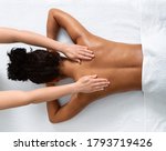 Slim black woman receiving full body massage at modern spa, top view