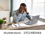 Small photo of Stressful Job. Stressed African Businessman At Laptop Touching Head Having Problem At Workplace Sitting In Modern Office. Crisis And Entrepreneurship Business Issues, Headache Concept