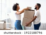 Small photo of Happy Black Spouses Packing Boxes For Moving, Relocating To New Apartment Standing At Home. Real Estate Rent, Mortgage And Ownership Concept. Family Preparing To Move House.