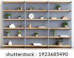 Blog about interiors, stylish design, Scandinavian style and decor elements at home. Gray wall, shelf with books, accessories, clock and potted plants in cozy living room, flat lay, free space