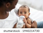 Small photo of Cute little African American baby drinking from baby bottle