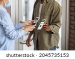 Covid-19 Control. Female Worker Scanning Health Qr Code Of Black Male Visitor On Entrance To Public Place, Unrecognizable African Man Demonstrating Digital Vaccination Certificate On Smartphone