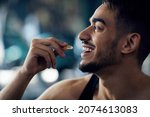 Small photo of Portrait Of Happy Sportive Arab Man Taking Supplement Capsule, Closeup Shot Of Young Middle Eastern Guy Eating Omega 3 Or Amino Acid Multivitamin Pill, Enjoying Fitness Nutrition, Cropped