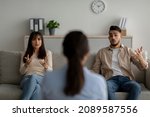 Small photo of Family counseling. Psychotherapist sitting back to camera looking at arab spouses blaming each other for relationship crisis at marital therapy session