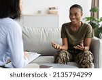 Small photo of Happy Black Soldier Woman Talking To Female Therapist During Meeting In Office, Smiling African American Military Lady In Camouflage Uniform Speaking With Counselor After Successful Therapy