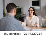 Positive hiring manager speaking to vacancy candidate during employment interview at modern company office. Personnel recruitment and headhunting, searching for job concept