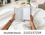 POV Of Man Holding Planner Planning His Day Lying In Bed At Home In The Morning. Unrecognizable Guy Holding Empty Business Diary In Hands In Modern Bedroom. Cropped Shot
