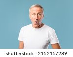 Small photo of Wow, Omg. Portrait Of Surprised Mature Guy Opened Mouth In Amazement, Shocked Man Looking Stunned And Impressed, Staring At Camera, Emotionally Reacting To News Isolated On Blue Studio Background