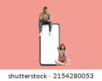 Small photo of Online Shopping, Remote Banking. Happy young couple sitting on big giant blank cell phone screen, guy using tablet, excited lady holding credit card and pc, purchasing in web store, buying on internet
