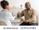 Small photo of Healthcare, Geriatric Medicine, Medical Check Up. Senior man visiting doctor telling about health complaints, female gp or nurse writing personal information, filling form listening to elderly patient