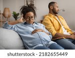 Small photo of Marital Crisis. Unhappy Pregnant Black Wife Sitting Near Indifferent Husband After Quarrel At Home. Divorce During Pregnancy, Relationship Problems Concept. Selective Focus