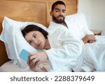 Small photo of Jealousy Problem. Husband Looking At Cheating Wife When Woman Texting On Smartphone Communicating Online Lying In Bedroom At Home. Jealous Boyfriend Suspecting Affair. Selective Focus