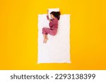 Small photo of Healthy Sleeping Routine. Peaceful Lady Lying On Blanket And Pillow Wearing Pajamas Napping In Fetal Position Over Yellow Studio Background, Top View. Recreation And Comfort Concept
