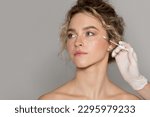 Beautician doctor making injection to young beautiful woman with drawn line under eye, lady with perfect smooth skin getting mesotherapy treatment or hyaluronic acid shot