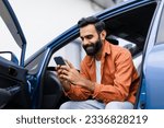 Small photo of Car Navigation Application. Happy Middle Eastern Man Using Phone Sitting In Auto With Opened Door, Searching Best Way Via Mobile Gps Navigator App, Posing With Gadget In Luxury Automobile