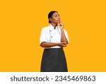 Portrait Of Pensive Young Black Chef Woman Looking At Copy Space And Touching Chin, African American Female Cook In Uniform Thinking About Interesting Offer, Standing Isolated On Yellow Background