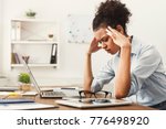 Tired african-american business woman with headache at office, feeling sick at work, copy space