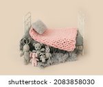 Newborn baby studio furniture bed for infant child photoshoot decorated with knitted toys. Tiny designed scene for kid studio portrait with pillow and blanket