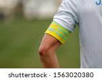 Captain of the football team on the stadium field. Sports background-the hand of the team captain with the identifying distinctive ribbon of the captain, official leader of team of footballers