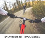 Dramatic shot of pair of young men mountain biking in a forest. POV Original point of view
