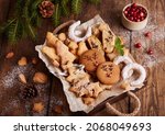 Box with variety of Christmas cookies: gingerbread deers, star with cranberries, Christmas trees with brown sugar, Biscotti cantucci with oranges, almonds and chocolate, horseshoe with sugar powder. 