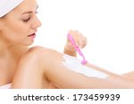 A picture of a young woman shaving her legs over white background