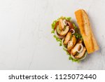 Chicken sandwich with tomato, cucumber, lettuce and onions. White stone background. Top view. Flat lay.