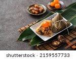 Small photo of Zongzi, rice dumpling for Chinese traditional Dragon Boat Festival (Duanwu Festival) on dark gray table background with ingredient.