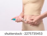 Close up woman using IVF treatment injection on belly to prepare reproductive fertility , Ovulation stimulation .	