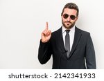 Small photo of Young caucasian bodyguard man isolated on white background showing number one with finger.