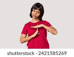Small photo of Young Hispanic woman with short black hair in studio showing a timeout gesture.