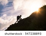 Young man climbing up a mountain. Self improvement and life goals concept. 