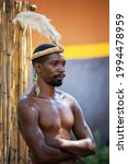 Small photo of Lesedi Cultural Village, South Africa - 4 November 2016: Zulu Warrior wearing impala skin and ostrich feather headdress. Zulu is one of five main tribes in South Africa and known for fighting skills.