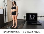 Small photo of Young woman in a medical office specializing in posturology with her feet on a platform to analyze the pressure exerted and the biomechanical study of footfall