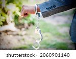 Small photo of hand release shackle The man's handcuffs were opened. acquitted innocent defendant gray suit businessman cessation of criminal proceedings.
