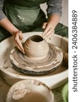 Small photo of Close-up of hands creating ceramic mould from clay in potters workshop Female potter's hands moulding the walls of clay ware on potters wheel.