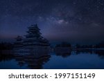 Old castle in japan. Matsumoto castle against night sky. Castle in Winter with milky way on sky .Travel Matsumoto Castle with frozen pond in Winter. A Japanese premier historic castles	
